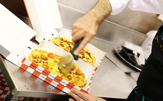 Pizza being sliced ready for a customer in La Piazza pizzeria in Nottingham